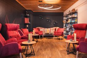 Nebenraum mit bequemen Stühlen und Bücherregal