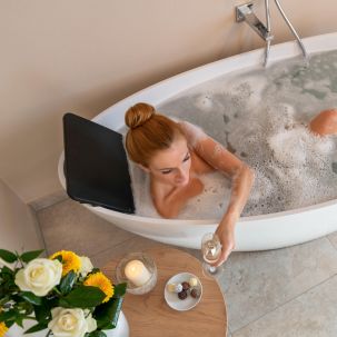 Frau entspannt in der Badewanne mit einem Glas Sekt