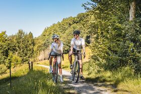 Paar fährt auf Feldweg bei schönem Wetter