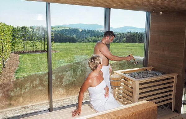 Paar genießt Sauna Aufguss in Panoramasauna