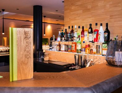 Blick auf den Tresen der Hotelbar mit verschiedenen, beleuchteten Spirituosenflaschen