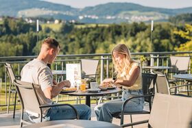 Paar frühstückt auf der Terrasse im Wellnesshotel