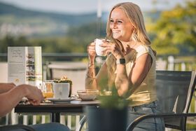 Frau trinkt Kaffee in der Sonne