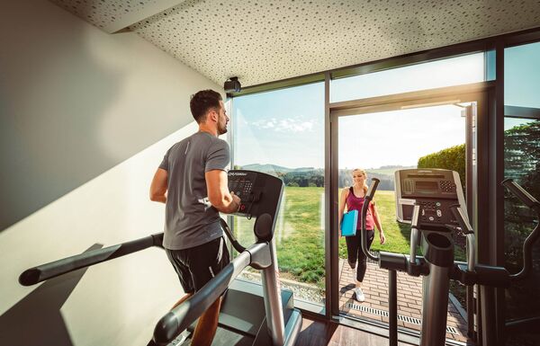 Mann läuft auf Laufband im Fitnessraum