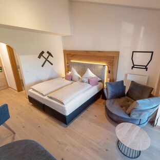 Zimmeransicht mit Boxspringbett und Kuschelsessel