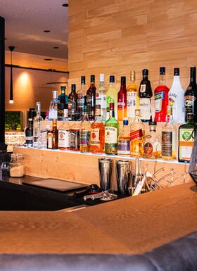 Blick auf den Tresen der Hotelbar mit verschiedenen, beleuchteten Spirituosenflaschen