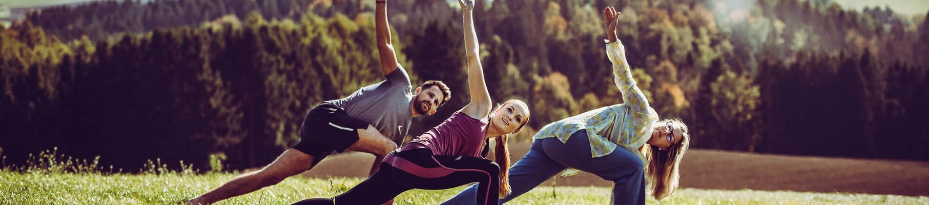 Gruppe macht Qi Gong im Hotelgarten mit herrlichem Ausblick auf Wald und Hügel