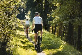 Paar fährt auf Feldweg bei schönem Wetter