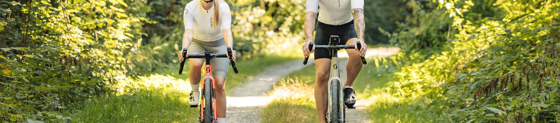 Paar fährt auf Feldweg bei schönem Wetter