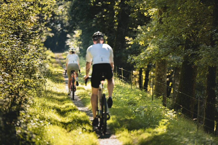 Paar fährt auf Feldweg bei schönem Wetter