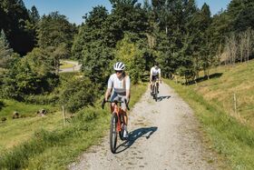 Paar fährt auf Feldweg bei schönem Wetter