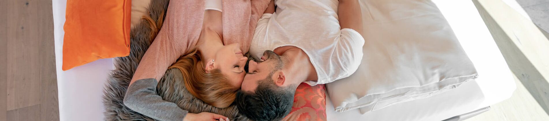 Paar kuschelt auf großem Boxspringbett