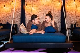 Paar entspannt auf einer kuscheligen Liege im Ruheraum