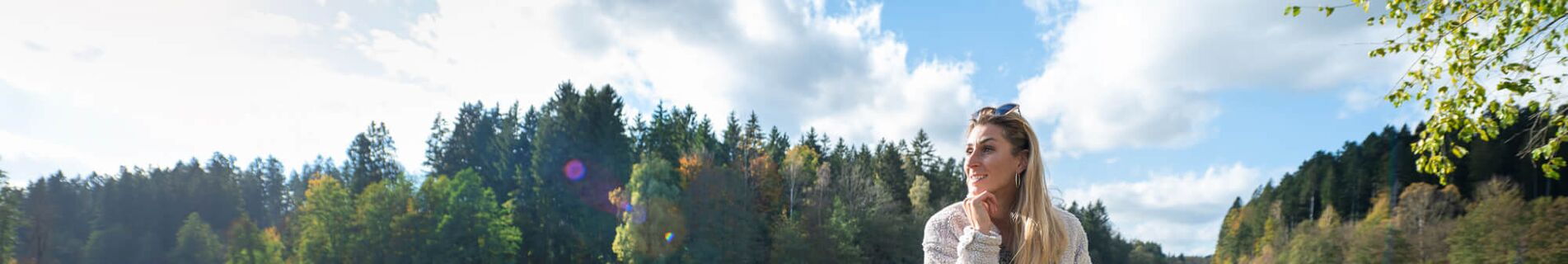Frau sitzt auf Bank mit Blick auf den Rannasee