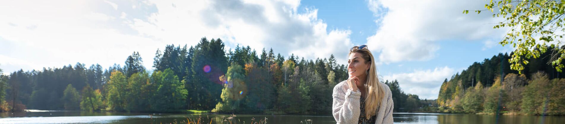 Frau sitzt auf Bank mit Blick auf den Rannasee