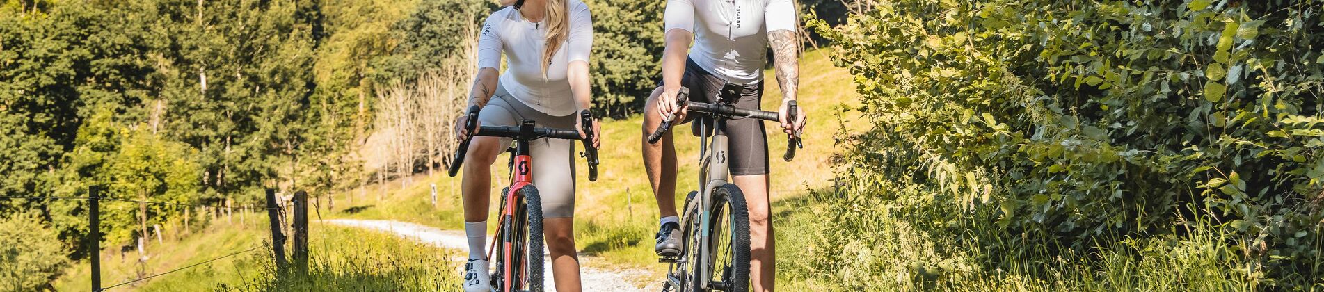 Paar fährt auf Feldweg bei schönem Wetter