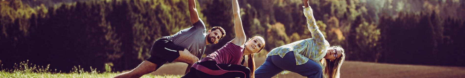 Gruppe macht Qi Gong im Hotelgarten mit herrlichem Ausblick auf Wald und Hügel