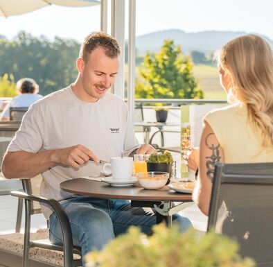 Paar frühstückt auf der Terrasse im Wellnesshotel
