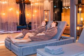 Paar entspannt auf einer kuscheligen Liege im Ruheraum