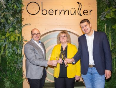 Inhaberfamilie vom Wellnesshotel im Bayerischen Wald Wolfgang, Michaela und Jonas Obermüller stoßen mit einem Glas Sekt an.