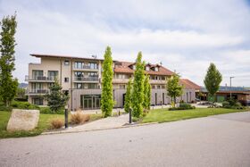 Hotelansicht von vorne mit Weg und Baumbepflanzung