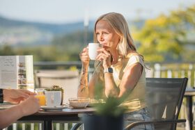 Frau trinkt Kaffee in der Sonne