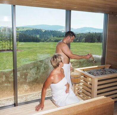 Paar genießt Sauna Aufguss in Panoramasauna