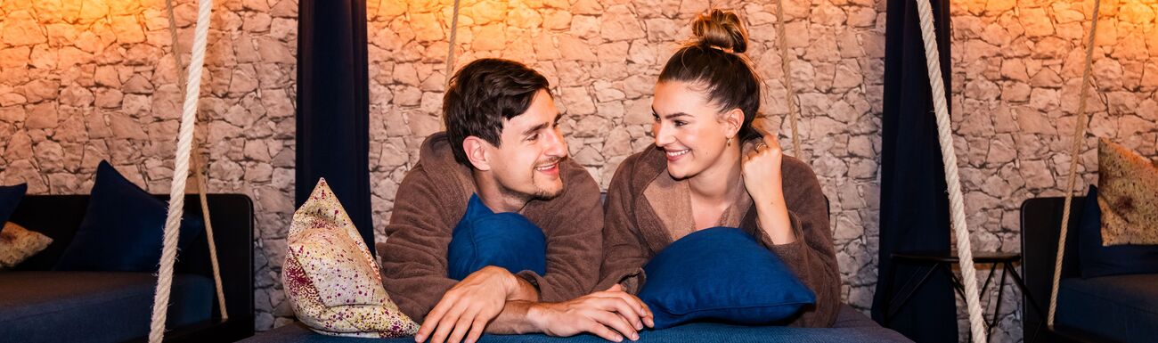 Paar liegt auf einer großen Schaukelliege im Ruheraum