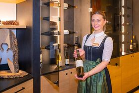 Mitarbeiterin präsentiert Weinflasche