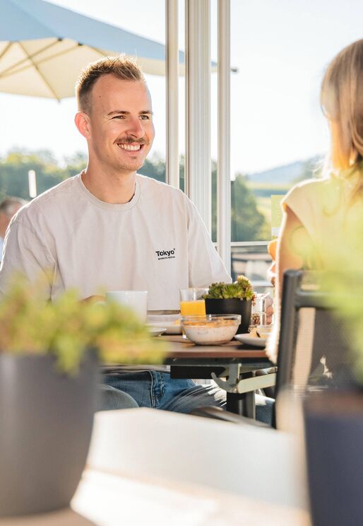 Paar frühstückt auf der Terrasse im Wellnesshotel