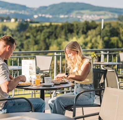 Paar frühstückt auf der Terrasse im Wellnesshotel