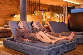 Paar entspannt auf einer kuscheligen Liege im Ruheraum