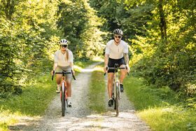 Paar fährt auf Feldweg bei schönem Wetter