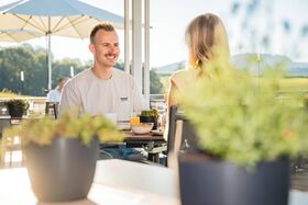 Paar frühstückt auf der Terrasse im Wellnesshotel