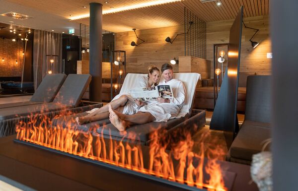 Paar entspannt im Ruheraum vor Kamin