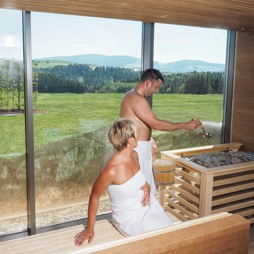 Paar genießt Sauna Aufguss in Panoramasauna